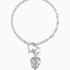 A silver chain bracelet with a toggle clasp and a dangling heart-shaped charm featuring a small apple detail, shown on a plain white background.