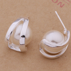 Silver hoop earrings on a brown background