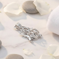 Back of a mermaid sterling silver pearl cage pendant on a white spa background.