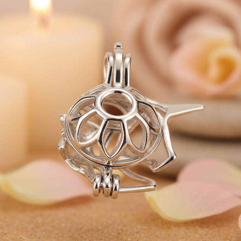 Back of a sterling silver unicorn pearl cage pendant shaped shown on a warm tan background and pink petals.