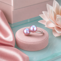 Double pearl sterling silver ring on a pink circular jewelry riser with a pink lotus flower in the soft pink and aquas background