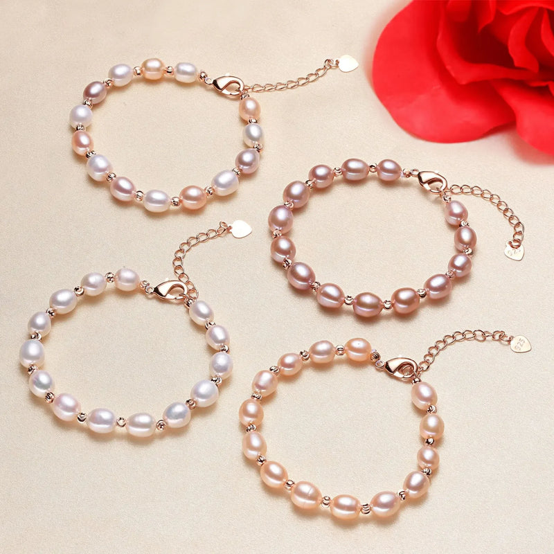 Set of pearl bracelets on a beige background with a red flower.