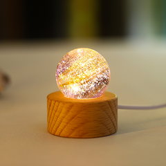 A purple translucent glass orb with frosted lunar‑style textures, illuminated on a wooden base.