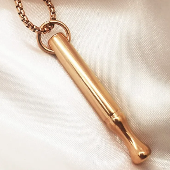 Gold necklace pendant on a light fabric background