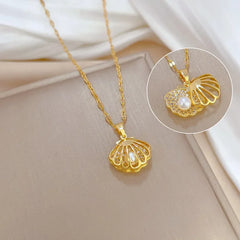 Gold necklace with shell pendant featuring a pearl on a light background