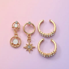 Set of gold earrings with star and moon designs on a white background