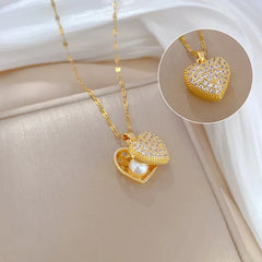 Gold heart-shaped necklace with a pearl inside on a white background