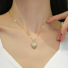 Gold necklace with a heart-shaped diamond pendant on a woman's neckline.
