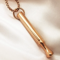 Gold necklace pendant on a light fabric background