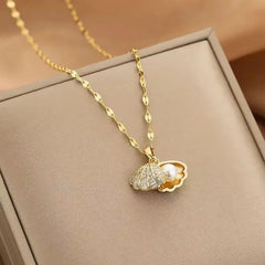 Gold necklace with a pendant on a beige surface