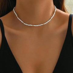 Pearl necklace worn by a person against a neutral background