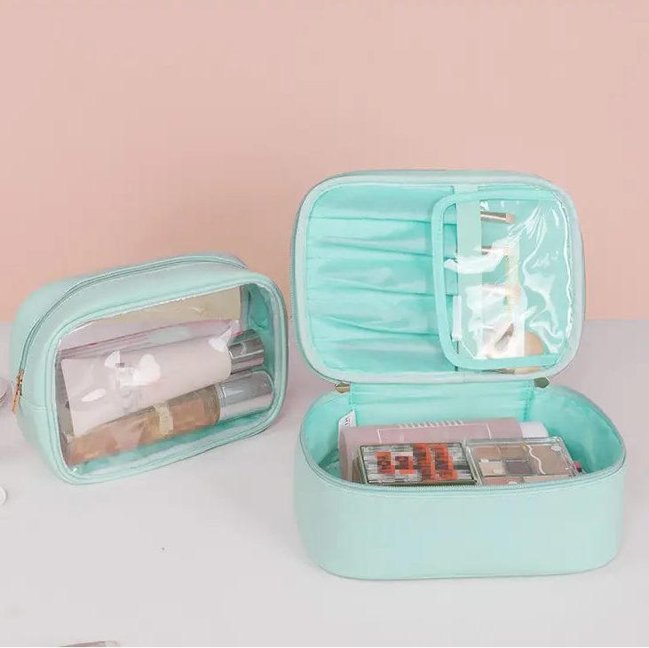 Mint green cosmetic bag with makeup items on a light pink background