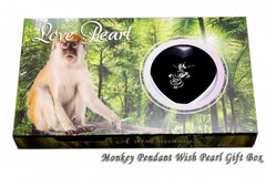 Gift box with monkey pendant and 'Love Pearl' text on a forest background