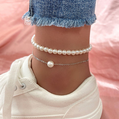 Pearl anklets on a person's ankle with a blurred background