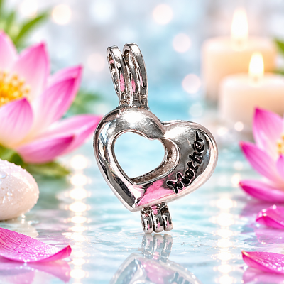 A silver heart-shaped pendant with a smaller heart cutout in the center and the word 'Mother' engraved on one side, shown in a spa-like setting with pink lotus flowers, petals, and lit candles in the background.