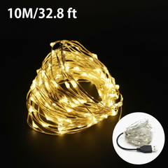 Warm white USB LED fairy lights shining with a soft, cozy golden glow on flexible copper wire.