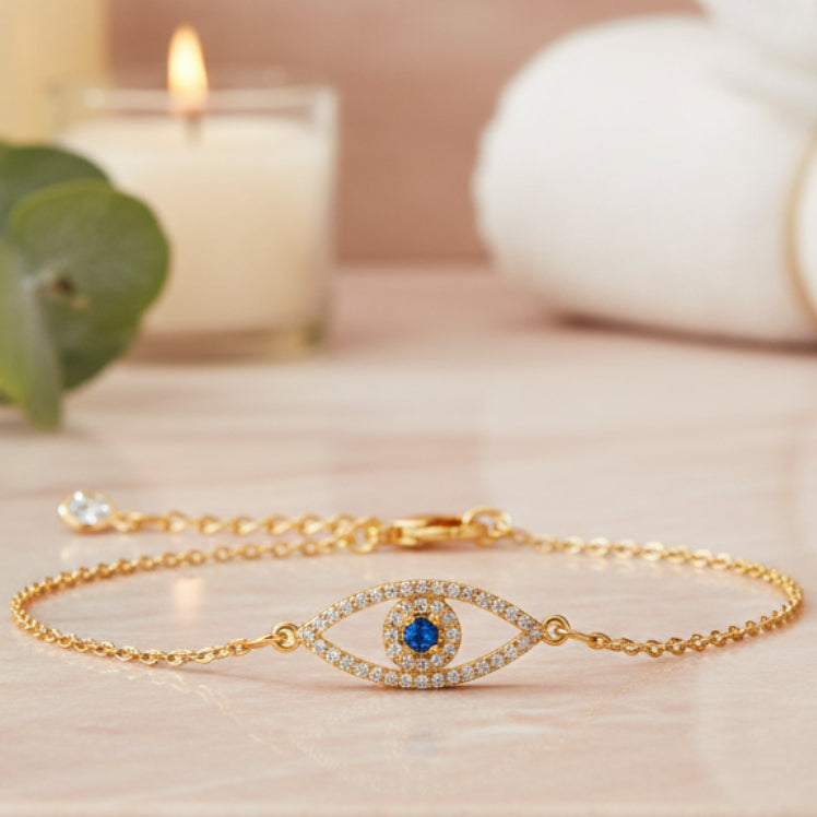 Gold evil eye bracelet with blue center stone and clear crystal accents on an adjustable chain
