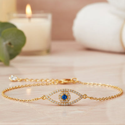 Gold evil eye bracelet with blue center stone and clear crystal accents on an adjustable chain