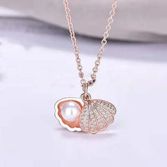 Necklace with a shell and pearl pendant on a light background