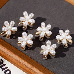 Set of pearl flower earrings on a dark surface
