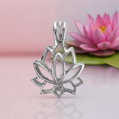 A polished silver lotus‑shaped pendant with open petal outlines displayed against a soft pink‑lavender background. A realistic pink lotus flower with green leaves sits naturally offset to the right, adding a serene, boutique‑magical touch without altering the jewelry focus.
