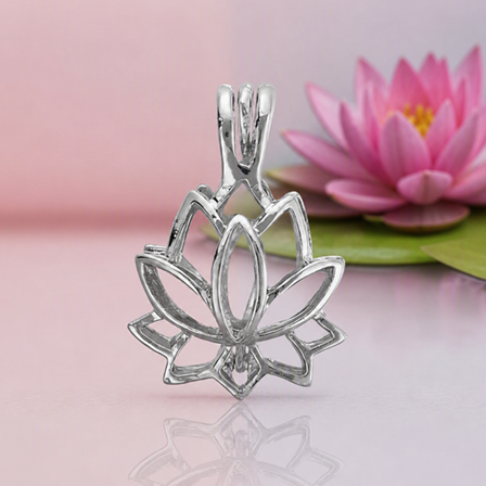 A polished silver lotus‑shaped pendant with open petal outlines displayed against a soft pink‑lavender background. A realistic pink lotus flower with green leaves sits naturally offset to the right, adding a serene, boutique‑magical touch without altering the jewelry focus.