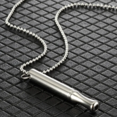 Silver necklace with a cylindrical pendant on a textured black surface