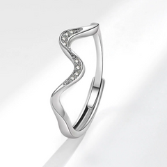 Silver ring with a wavy design and small diamonds on a light gray background