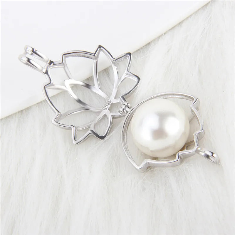 A sterling silver-toned metal flower-shaped pearl cage displayed open demonstrating a white pearl inside it on a white textured surface.