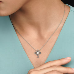 Sterling Silver cross freshwater pearl necklace on a person's neck with a aqua blouse