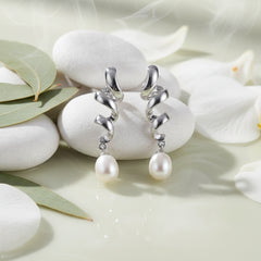 Sterling silver White Pearl earrings against a stone with leaves