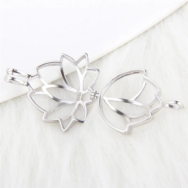A sterling silver-toned metal flower-shaped pearl cage displayed open on a white textured surface.