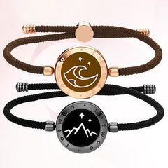 Two bracelets with circular emblem designs on a light pink background