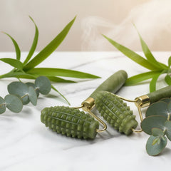 Green massage roller with gold accents on a white background