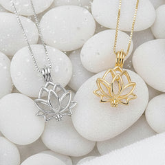 Two lotus flower pendant necklaces on delicate chains, one in silver and one in gold, displayed on a white stone background.