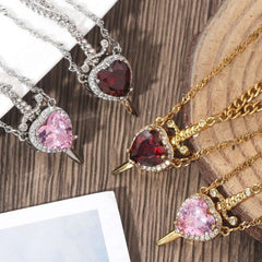 Three necklaces with heart-shaped gemstones on a wooden surface