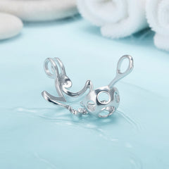 The back of a sterling silver starfish pearl cage charm photographed on a pale blue background.