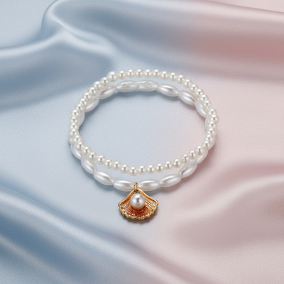 Pearl bracelet with a gold shell charm on a white background