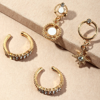 Gold hoop earrings with gemstone accents on a beige surface