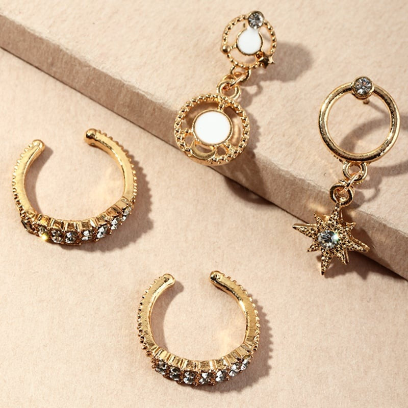 Gold hoop earrings with gemstone accents on a beige surface