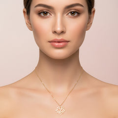 Gold lotus flower necklace on a model's neckline