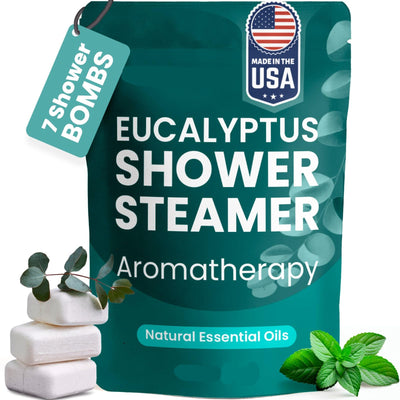 Green eucalyptus shower steamer pouch labeled seven shower bombs, beside white tablets and leaves.