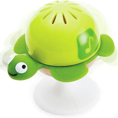 Green turtle-shaped bath toy with a music note on a white background