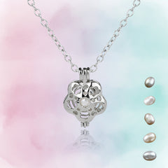 Elegant silver flower-shaped cage pendant necklace featuring a central pearl and loose pearls displayed on a soft pastel background.