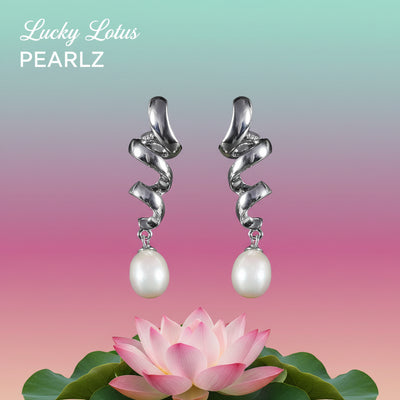 Sterling silver spiral drop earrings with white freshwater pearls displayed above a pastel background and pink lotus flower