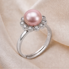 Elegant 925 sterling silver ring featuring a soft pink freshwater pearl surrounded by a sparkling flower halo design on a light cream background.