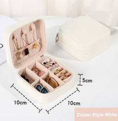 A compact square jewelry box shown open and closed on a white surface. The open box reveals interior compartments holding necklaces, earrings, and bracelets, with dimension labels indicating 10 cm by 10 cm and a 5 cm height.